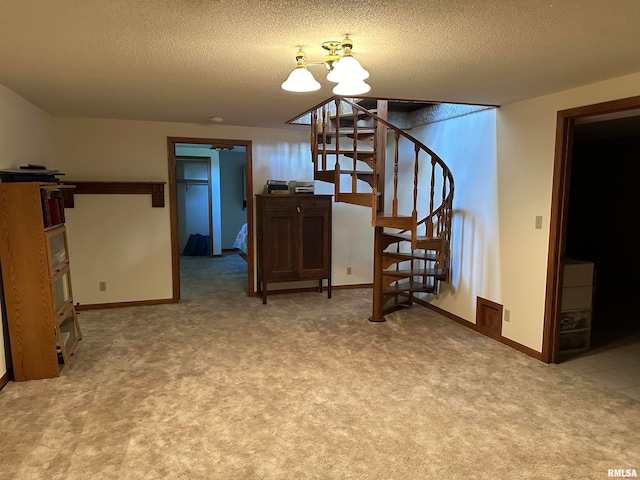 interior space featuring carpet flooring, a notable chandelier, and a textured ceiling