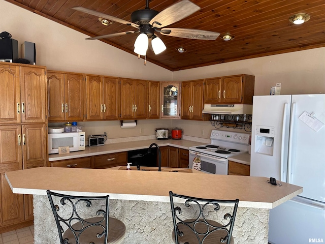 kitchen featuring a kitchen breakfast bar, lofted ceiling, sink, and white appliances