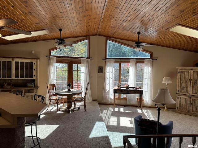 dining space with french doors, wooden ceiling, light colored carpet, lofted ceiling with skylight, and ceiling fan