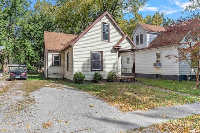 view of front of property with cooling unit and a front lawn