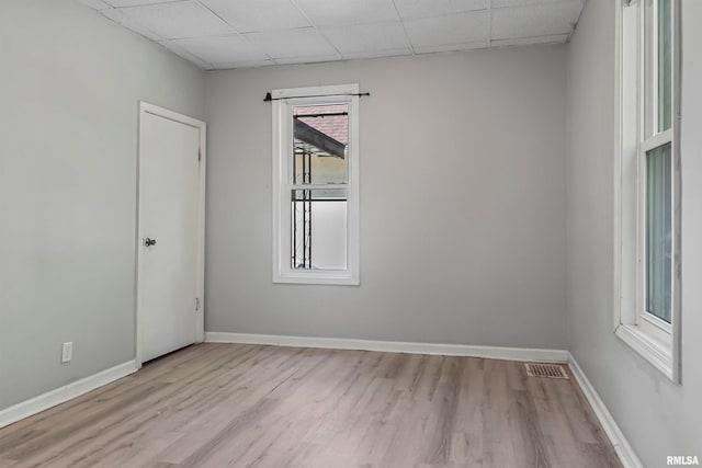 unfurnished room featuring a drop ceiling and light hardwood / wood-style floors