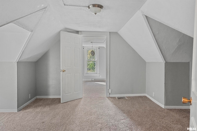 additional living space with carpet flooring and vaulted ceiling