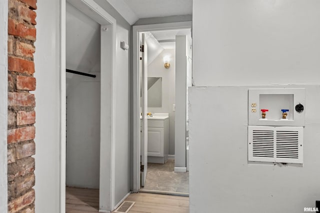 corridor with sink and light hardwood / wood-style floors