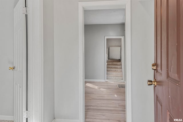 hallway featuring a textured ceiling and light hardwood / wood-style floors