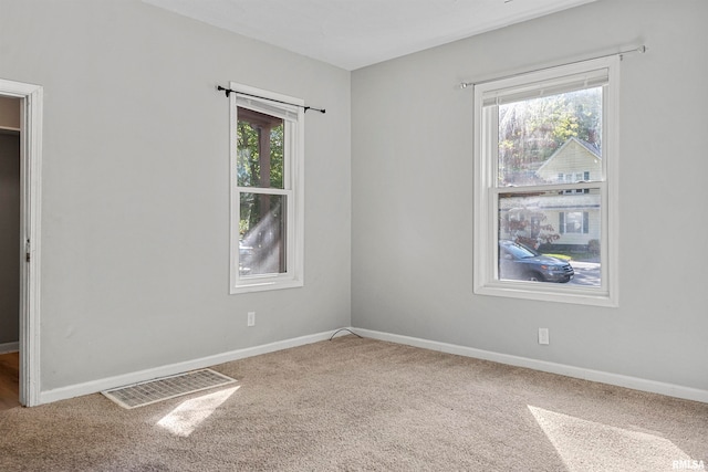 empty room with a healthy amount of sunlight and carpet