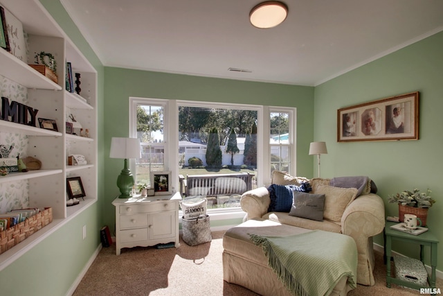 living area featuring ornamental molding and carpet