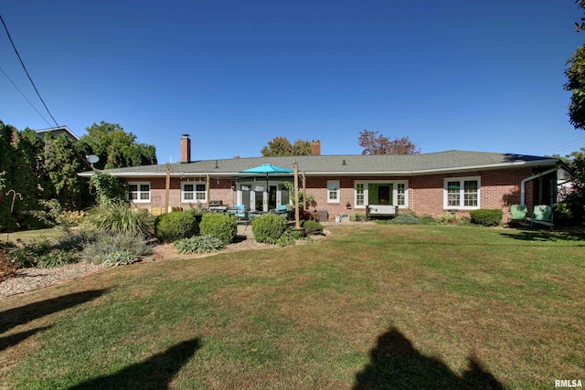 rear view of house featuring a yard