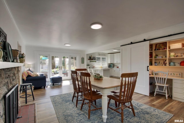 dining space featuring a barn door and hardwood / wood-style floors