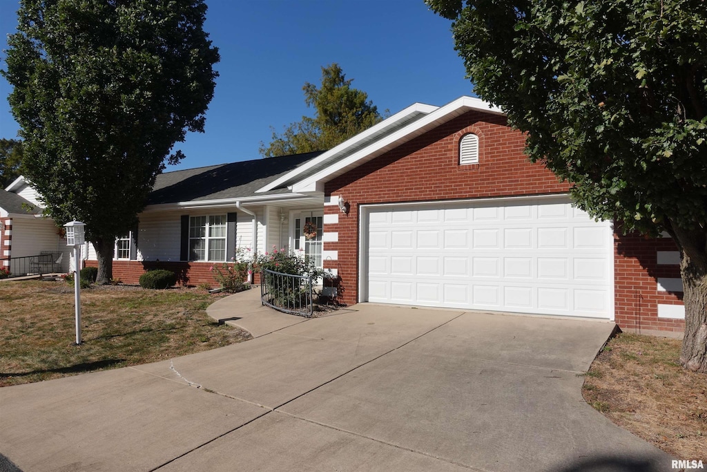 single story home featuring brick siding, a front lawn, an attached garage, and driveway