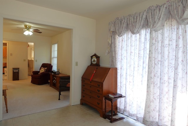 interior space with ceiling fan and light colored carpet