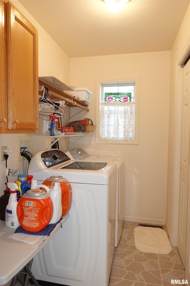 laundry area with cabinets, washer and dryer, and light tile patterned flooring