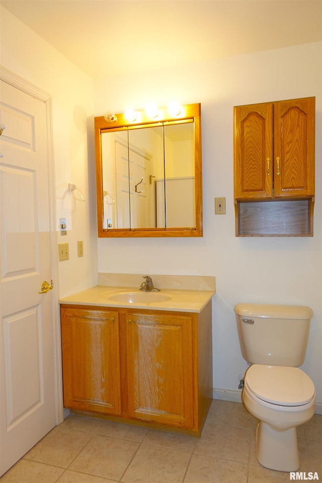 bathroom with tile patterned flooring, vanity, and toilet