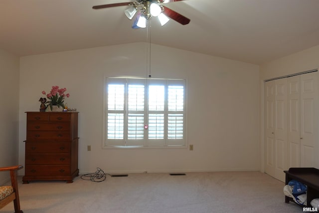 carpeted bedroom with ceiling fan, a closet, and vaulted ceiling