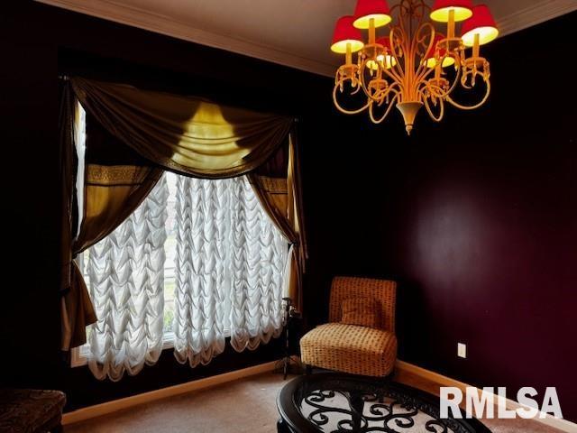 sitting room with a chandelier and crown molding