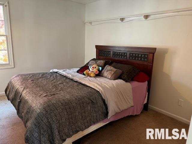 carpeted bedroom featuring multiple windows