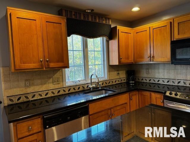 kitchen featuring decorative backsplash, appliances with stainless steel finishes, and sink