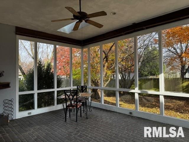 unfurnished sunroom with ceiling fan