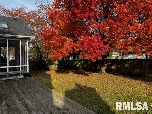 view of yard featuring a wooden deck and a sunroom