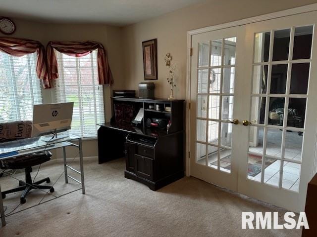 office area with a healthy amount of sunlight, light colored carpet, and french doors