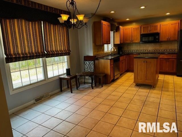 kitchen with black appliances, pendant lighting, light tile patterned floors, an inviting chandelier, and a center island