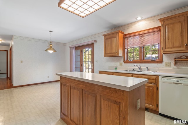 kitchen featuring sink, a healthy amount of sunlight, dishwasher, and hanging light fixtures