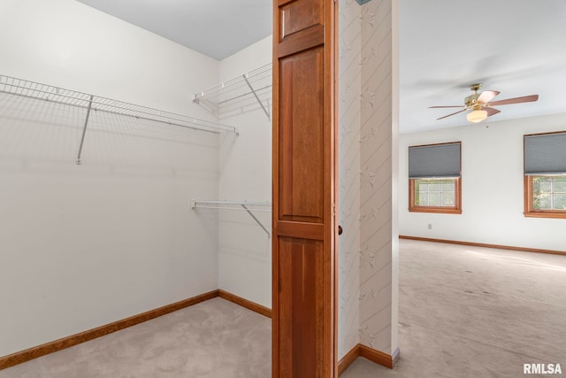 spacious closet with light carpet and ceiling fan