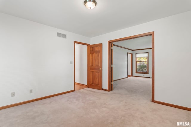 spare room featuring light colored carpet