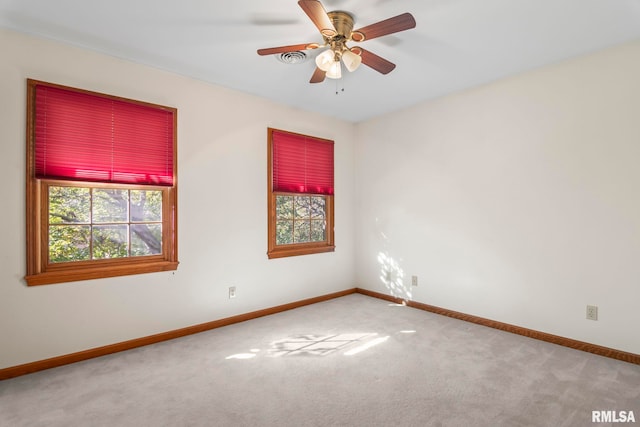 unfurnished room with ceiling fan and carpet