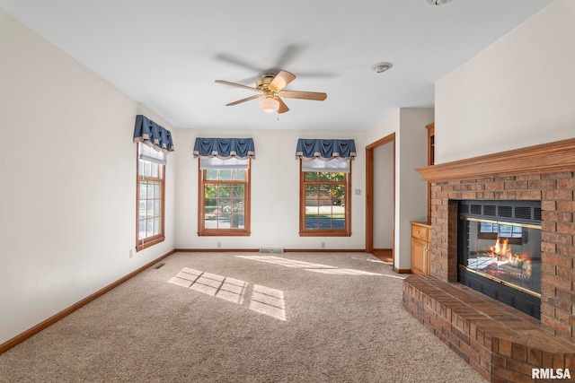 unfurnished living room featuring a fireplace, carpet floors, and ceiling fan