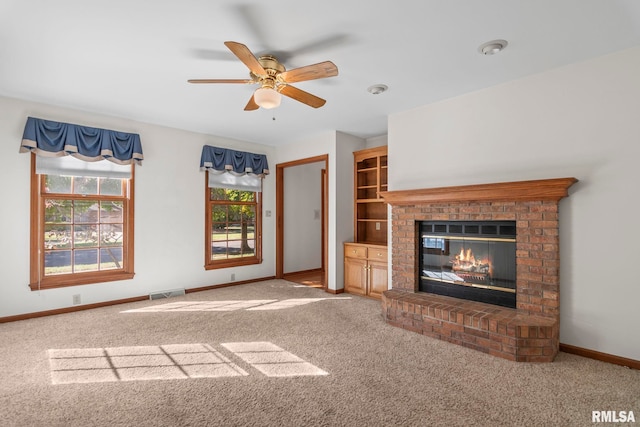 unfurnished living room featuring carpet floors, ceiling fan, and a brick fireplace