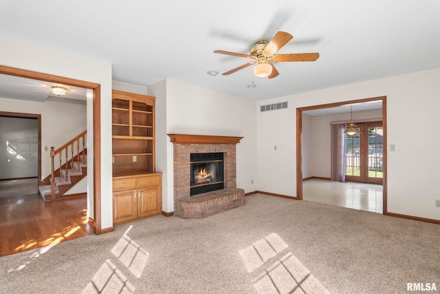 unfurnished living room featuring ceiling fan, carpet, and a fireplace