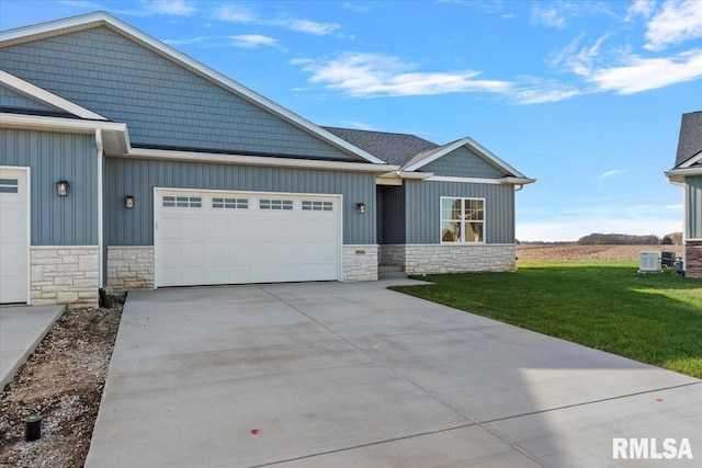 view of front of property with central AC, a front yard, and a garage