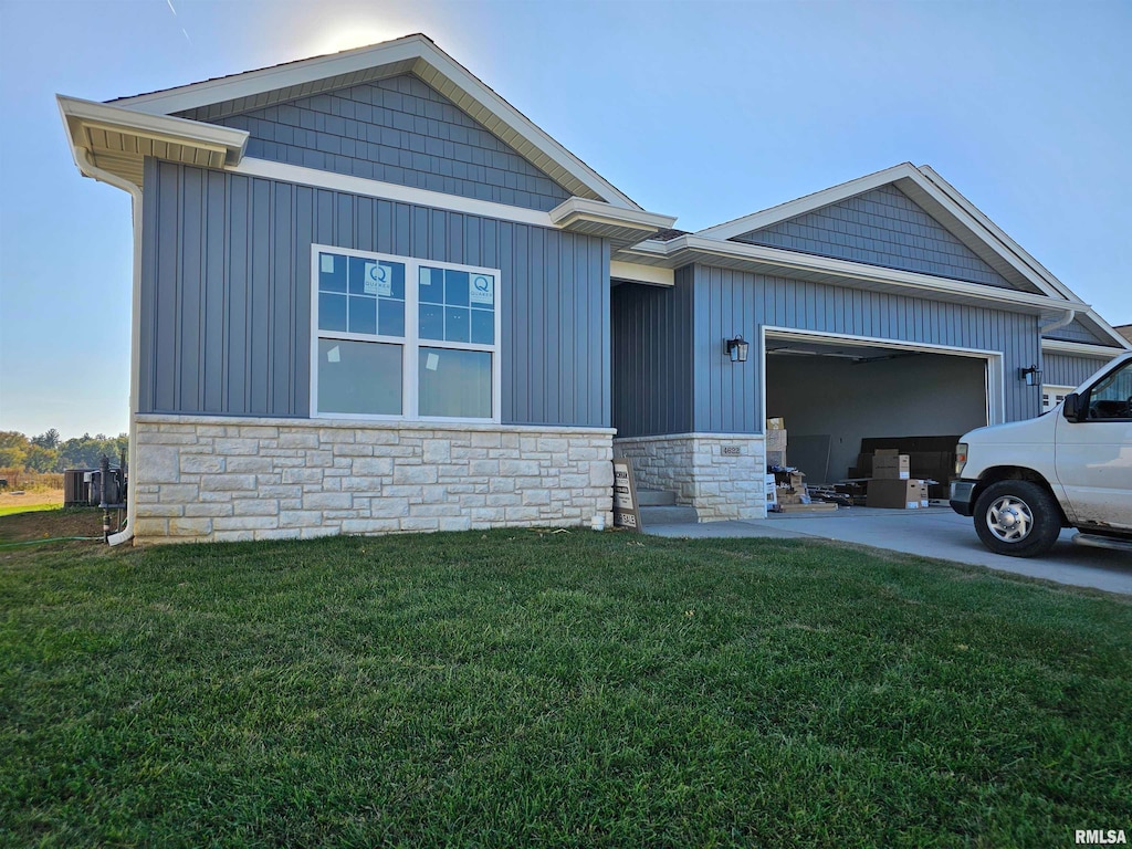 view of front of property with a front yard, a garage, and cooling unit