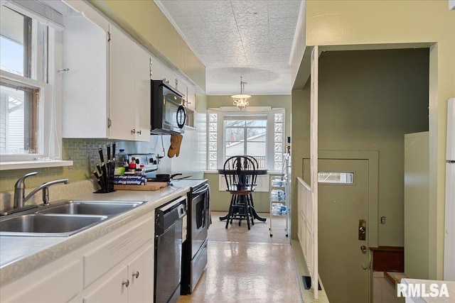 kitchen featuring black appliances, white cabinetry, and plenty of natural light