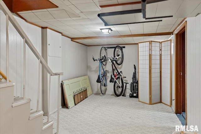 basement with wooden walls and light carpet