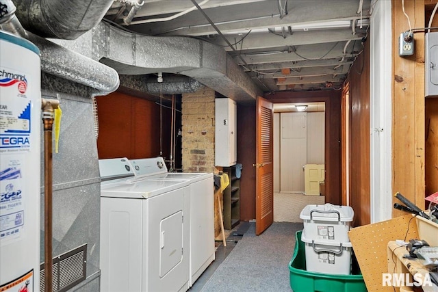 basement featuring electric panel, washing machine and dryer, and heating unit