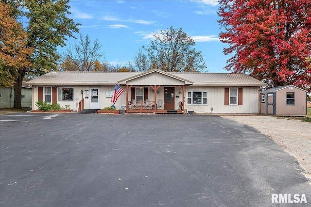 ranch-style house featuring a shed and covered porch