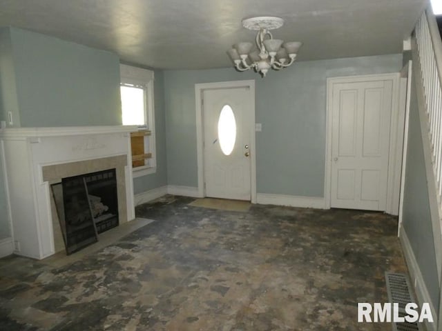 entryway with a chandelier, a fireplace with flush hearth, visible vents, and baseboards