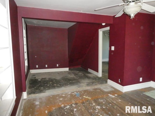 empty room featuring ceiling fan and baseboards