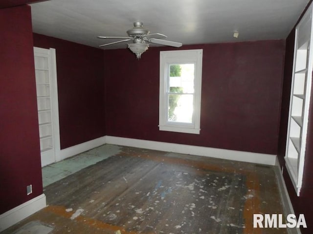 spare room with a ceiling fan and baseboards