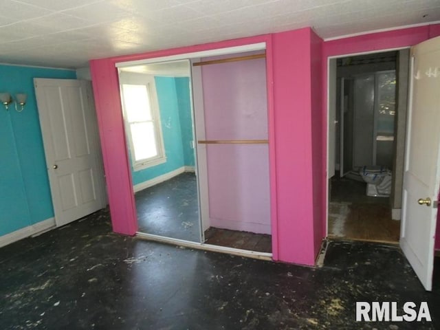 unfurnished bedroom featuring a closet and baseboards