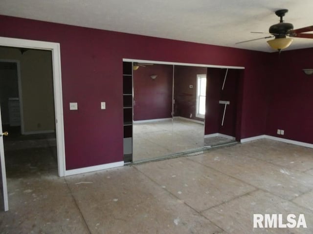 spare room with ceiling fan and baseboards