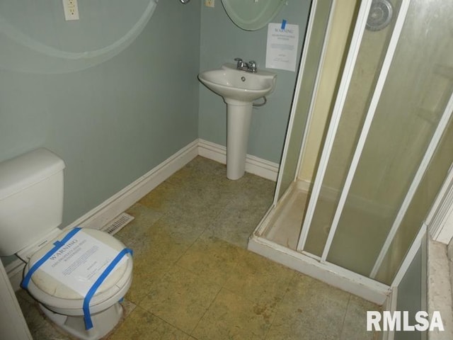 bathroom featuring visible vents, a stall shower, toilet, and baseboards