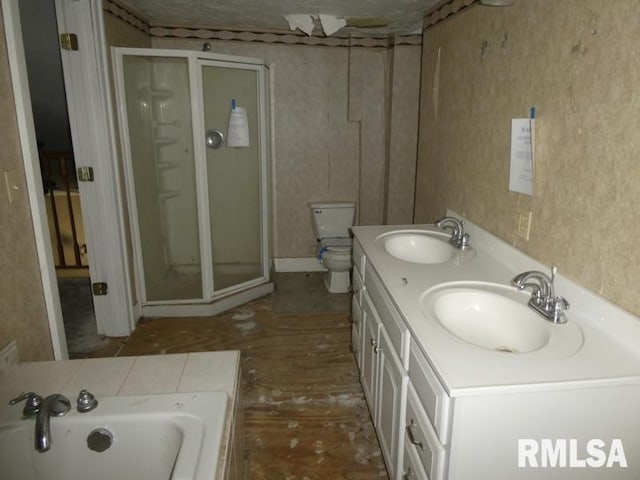 bathroom featuring a bath, double vanity, a sink, and toilet