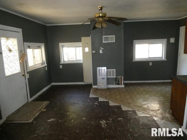 foyer entrance with crown molding, visible vents, plenty of natural light, and baseboards