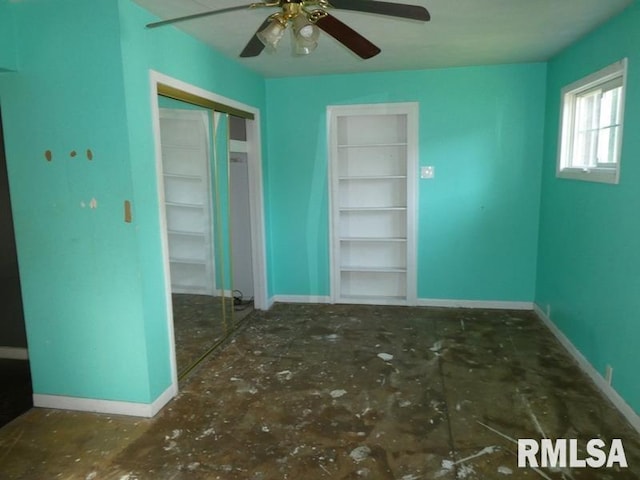 empty room with ceiling fan and baseboards