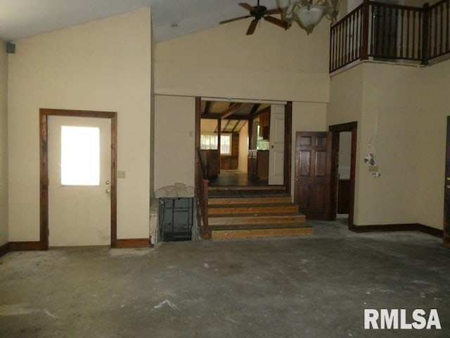 interior space featuring stairway, ceiling fan, high vaulted ceiling, and baseboards