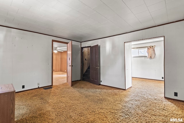 carpeted spare room with crown molding and ceiling fan