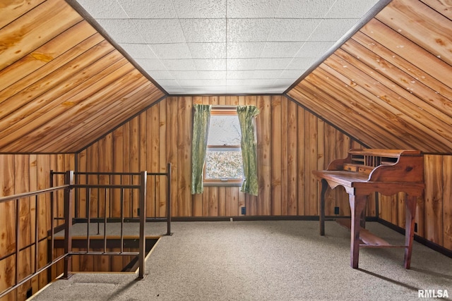 additional living space with carpet, vaulted ceiling, and wood walls