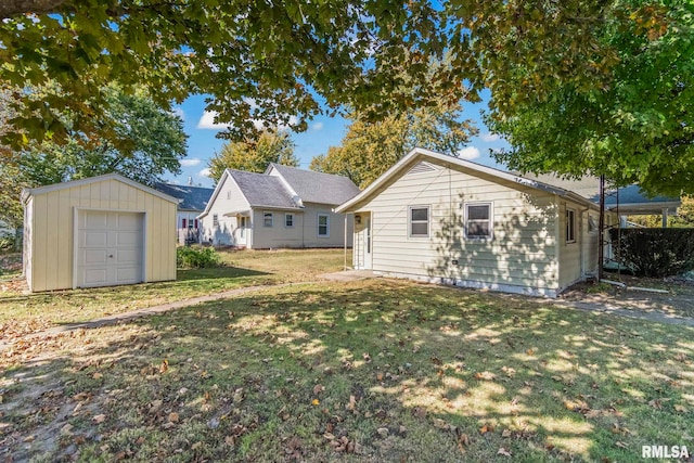 rear view of house with an outbuilding, a garage, and a lawn